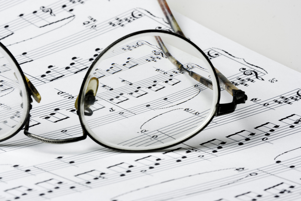 Round reading glasses resting on a sheet of violin music
