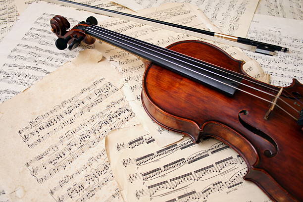 A violin and bow resting on aged sheet music